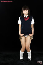 Kogal raising the hem of her uniform skirt knees pressed together wearing socks and shoes